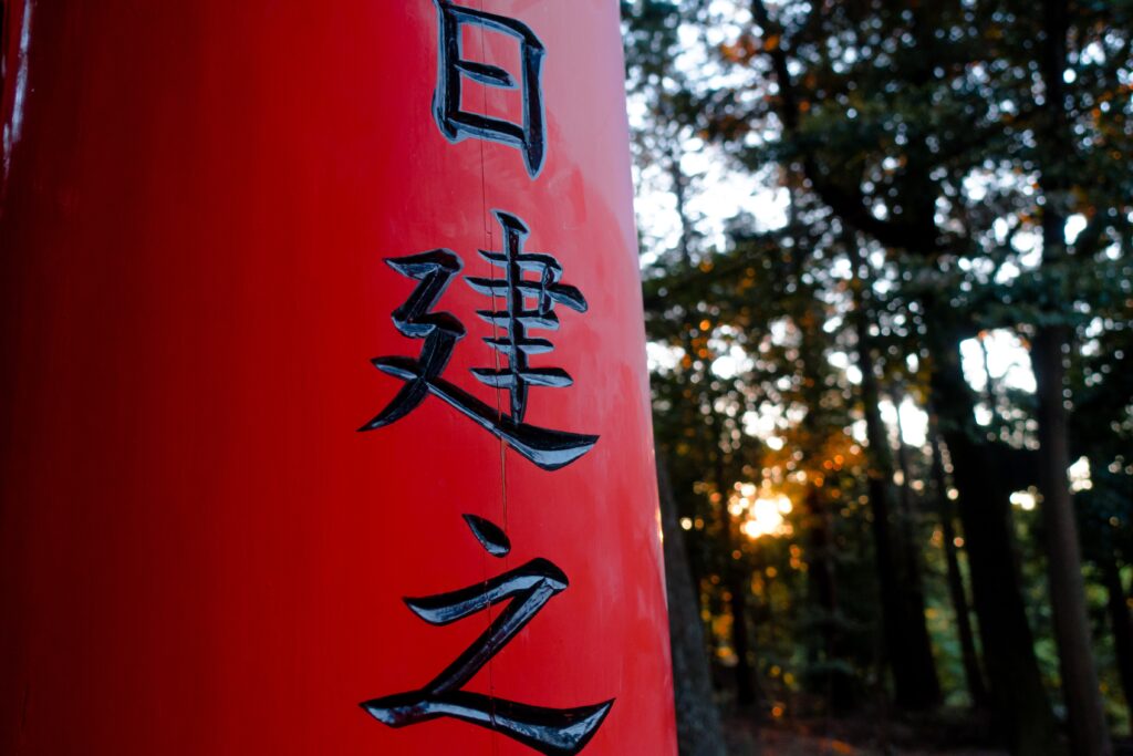 Japanese calligraphy on red item in the woods