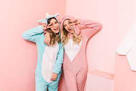 Two girls dressed in animal pajamas jumpsuit