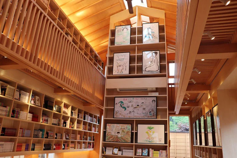 Interior of Manga-do manga library in Ura-Kusatsu Jizo with wooden tables and bookshelves