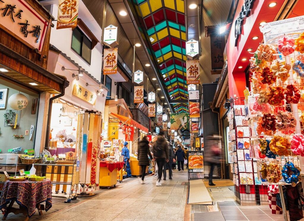 What to Do in Gion Kyoto in 2026: Beautiful Streets, Shrines and Local Experiences 19 Food stalls and shoppers inside Nishiki Market in Kyoto