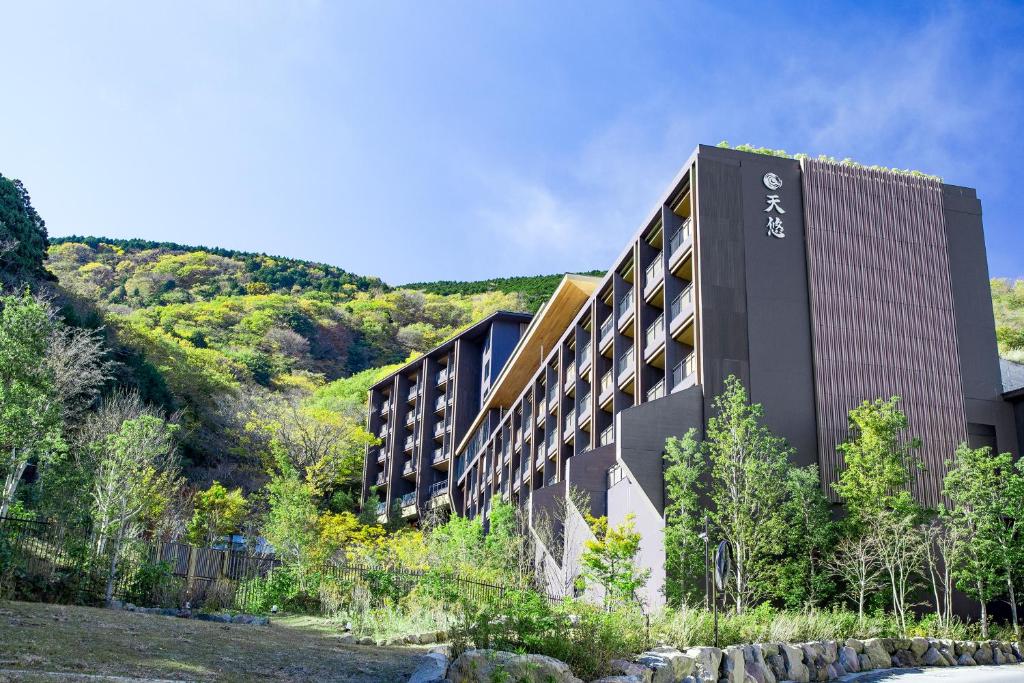 Hakone Kowakien Tenyu hotel exterior against green Hakone hills and a blue sky