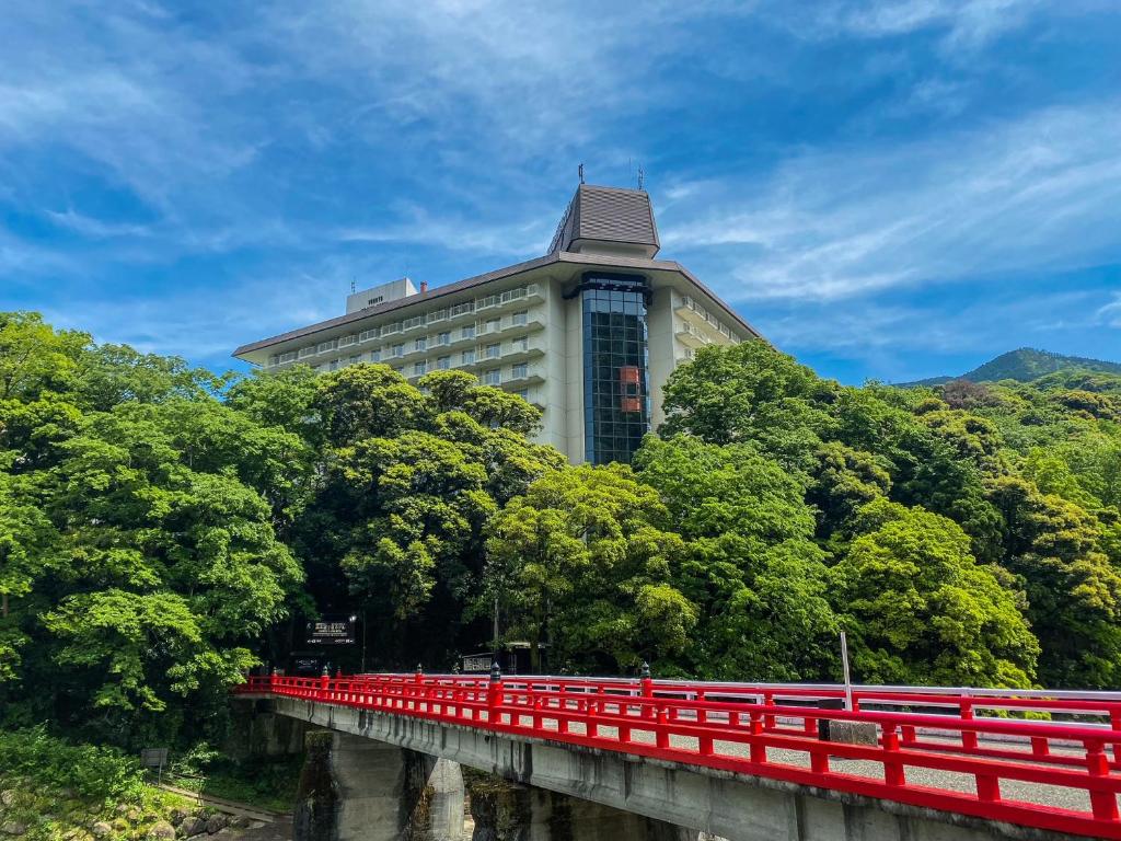 Yumoto Fujiya Hotel building above a red bridge and green trees in Hakone