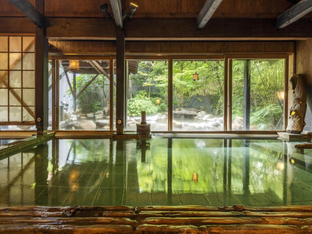 Indoor hot spring bath at Toki no Yu Setsugetsuka with windows overlooking a leafy garden