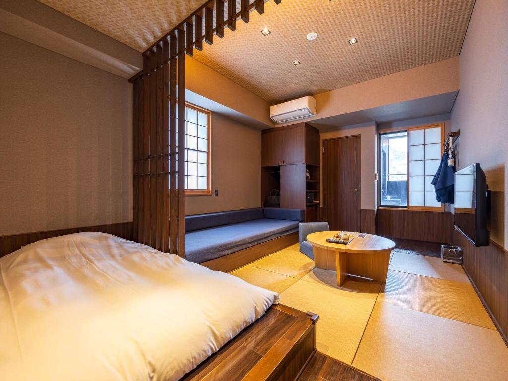 Tatami guest room at Susukinohara Ichinoyu with a bed, seating area, and private open-air bath