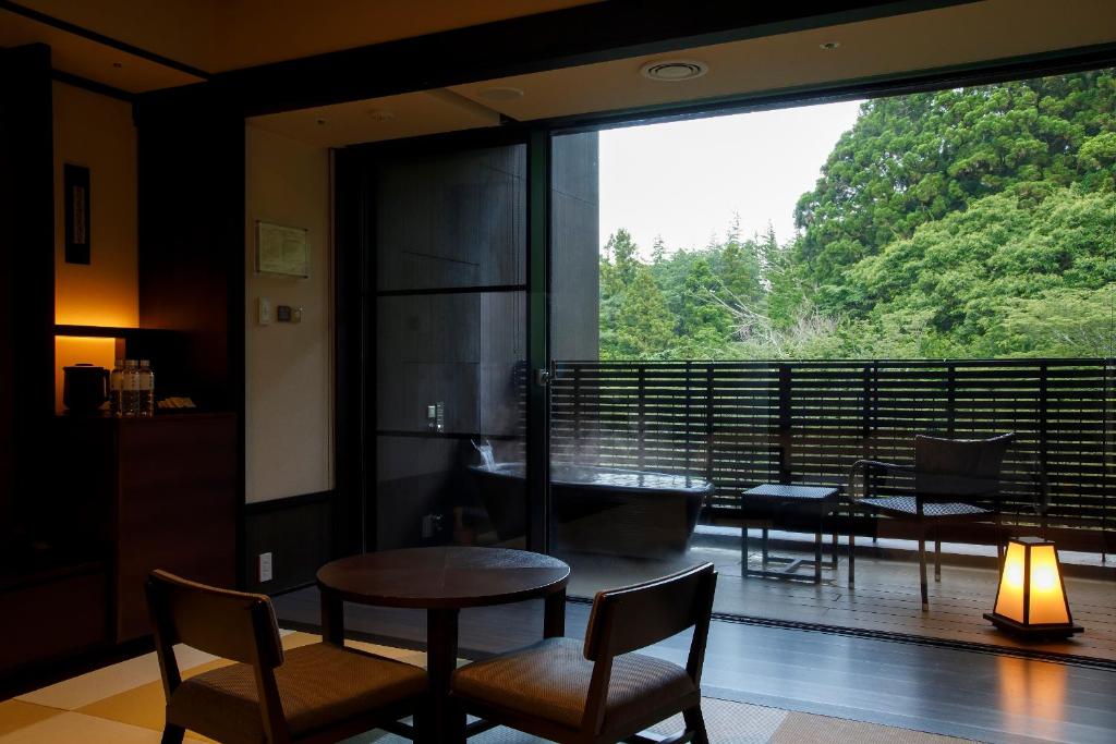Guest room at Hakone Kowakien Tenyu with tatami seating and a private open-air bath overlooking trees