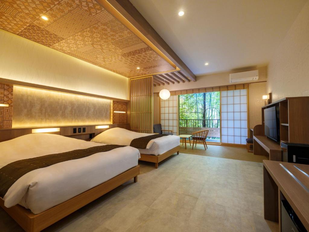 Twin room at Mizu no Oto with warm wood details, shoji screens, and forest views