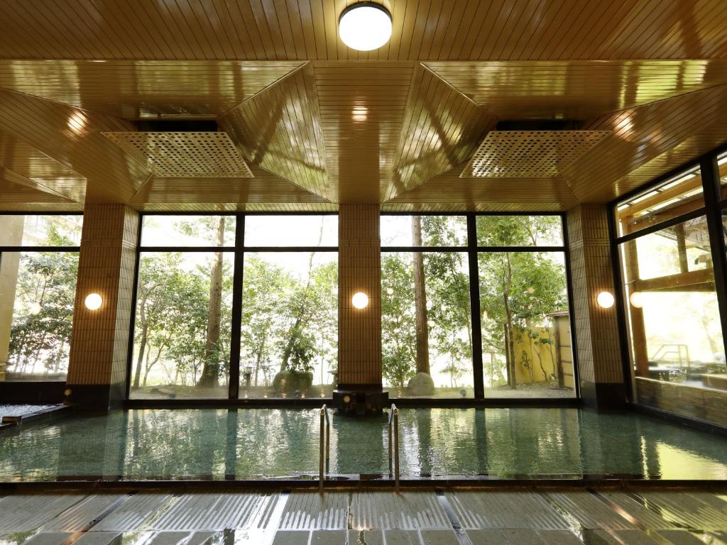 Indoor hot spring bath at Hotel Nanpuso with large windows facing trees
