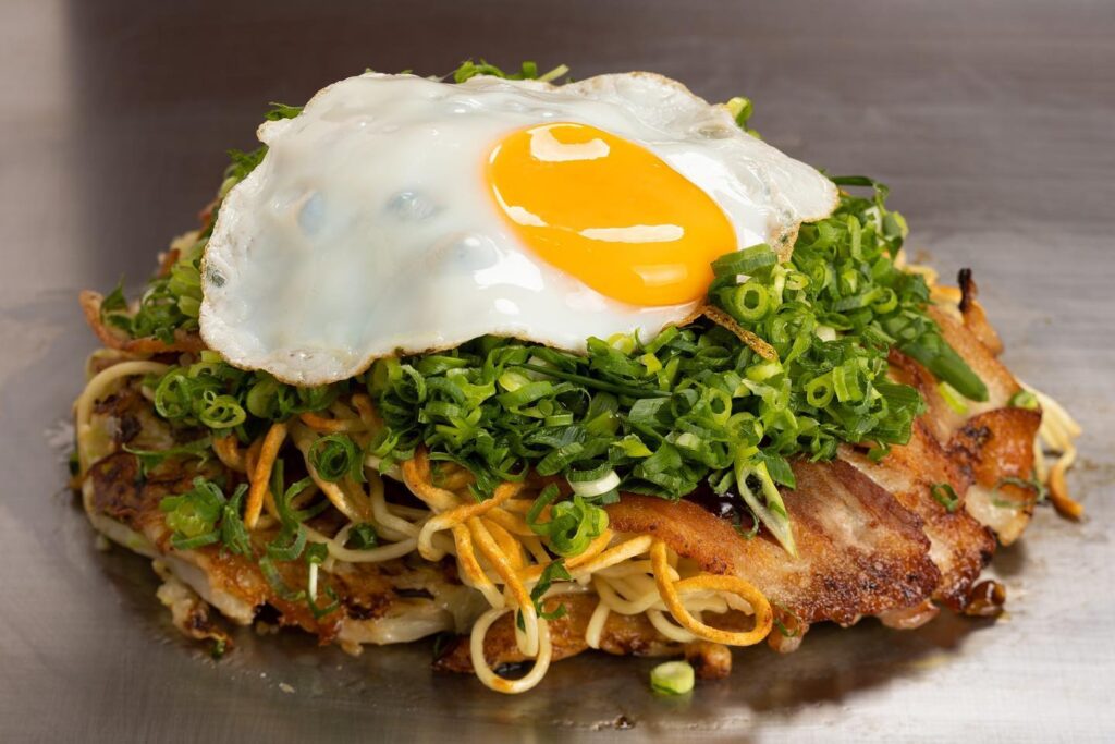Where to Eat in Kobe (2026): 21 Best Places for Kobe beef, sushi & local food 19 Sobameshi and okonomiyaki cooked on a teppan at Ganso Okonomiyaki Dojo