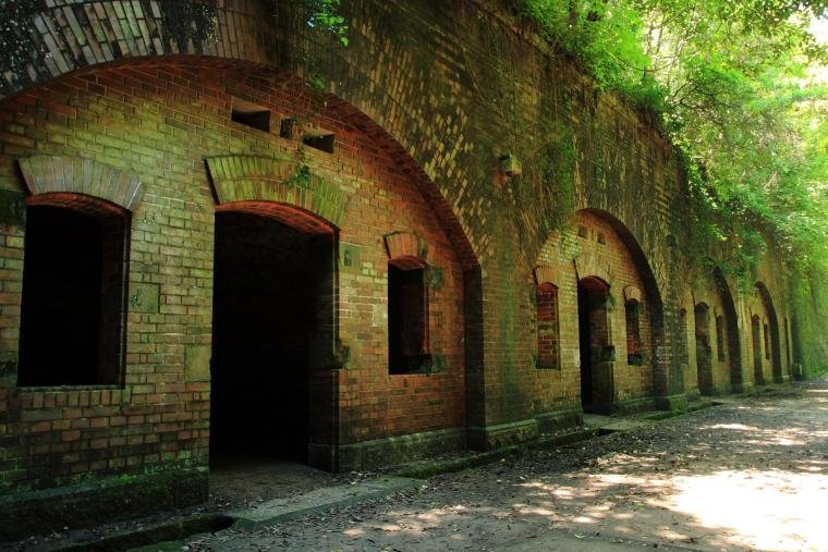 Abandoned brick military ruins surrounded by forest on Tomogashima Island