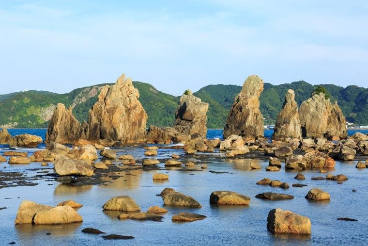 Row of tall Hashigui rock pillars stretching toward Oshima Island