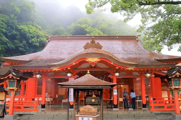 Vermilion buildings of Kumano Nachi Taisha surrounded by green mountains