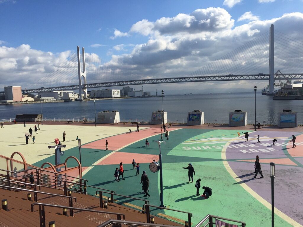 Best Shopping in Kobe Japan (2026): 25 Spots- Malls, Markets & Hidden Shops 25 Colourful waterfront plaza at Sunshine Wharf Kobe with a bridge in the background